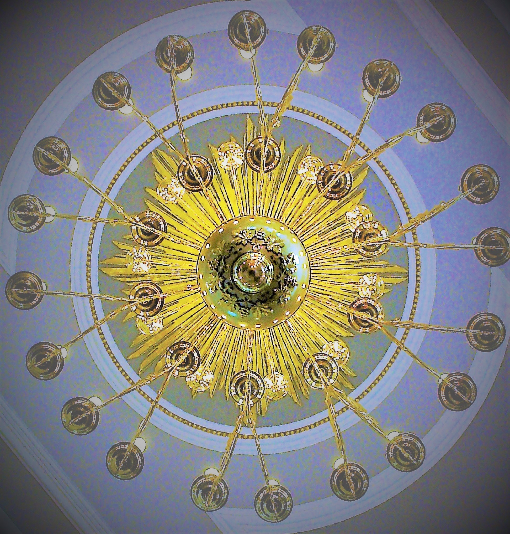 Ein Kronleuchter in einer Kirche, genau von unten fotografiert, was wie ein Symbol für einen Tanzkreis wirkt
