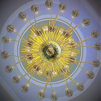 Ein Kronleuchter in einer Kirche, genau von unten fotografiert, was wie ein Symbol für einen Tanzkreis wirkt