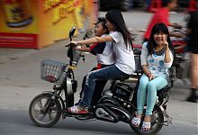 drei Personen auf einem Motorroller in China