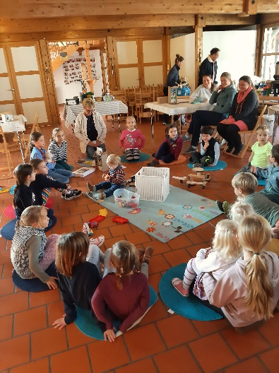 Zahlreiche Kinder lauschen im Sitzkreis Dagmar Heinz-Karisch bei der Vorbesprechung zum Bau von Insektenhotels